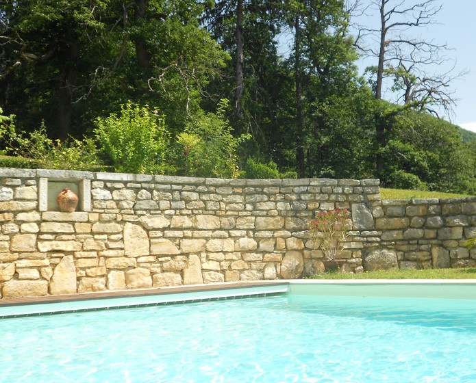 Création d'une piscine avec un mur en pierre